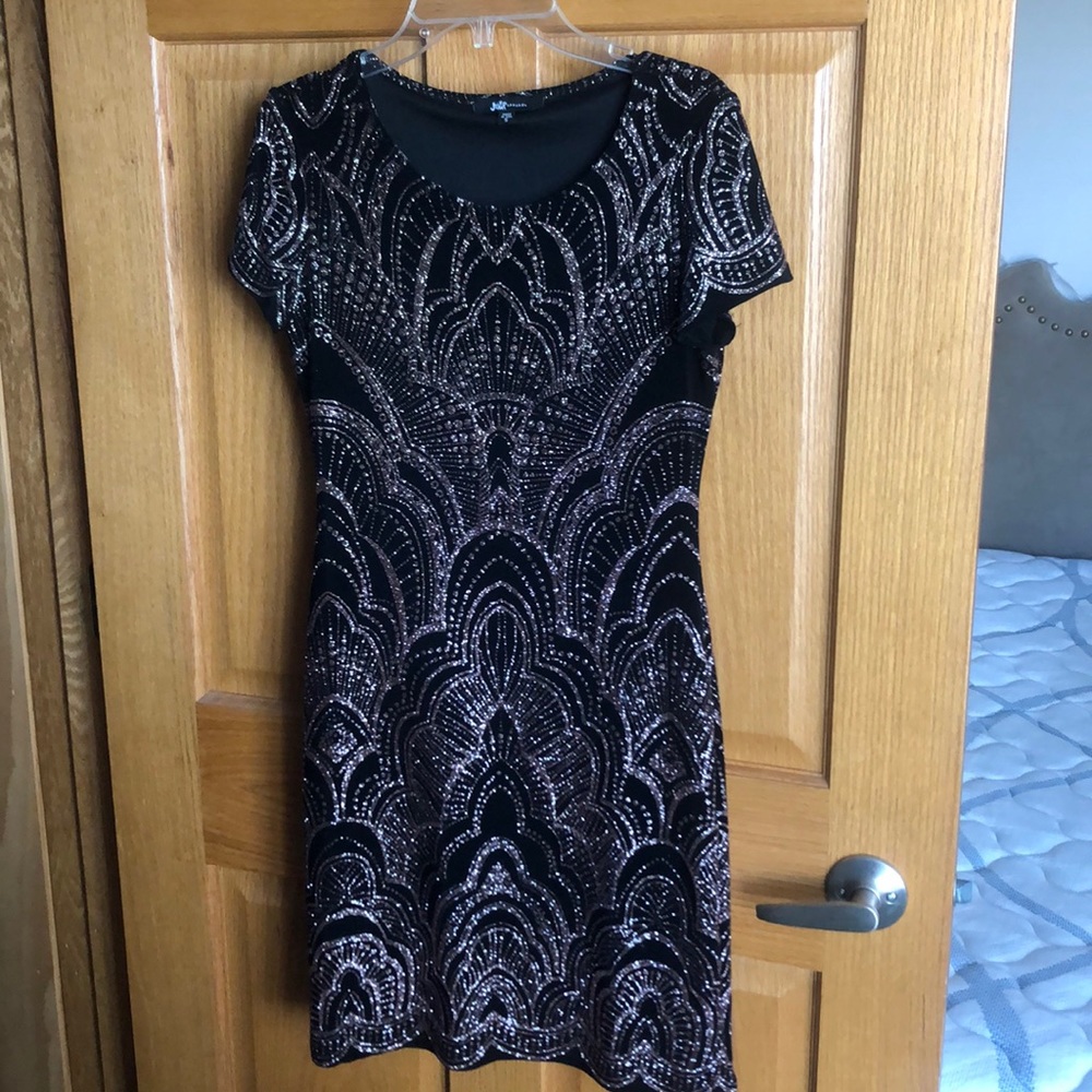 Mini black dress with rose gold detail.